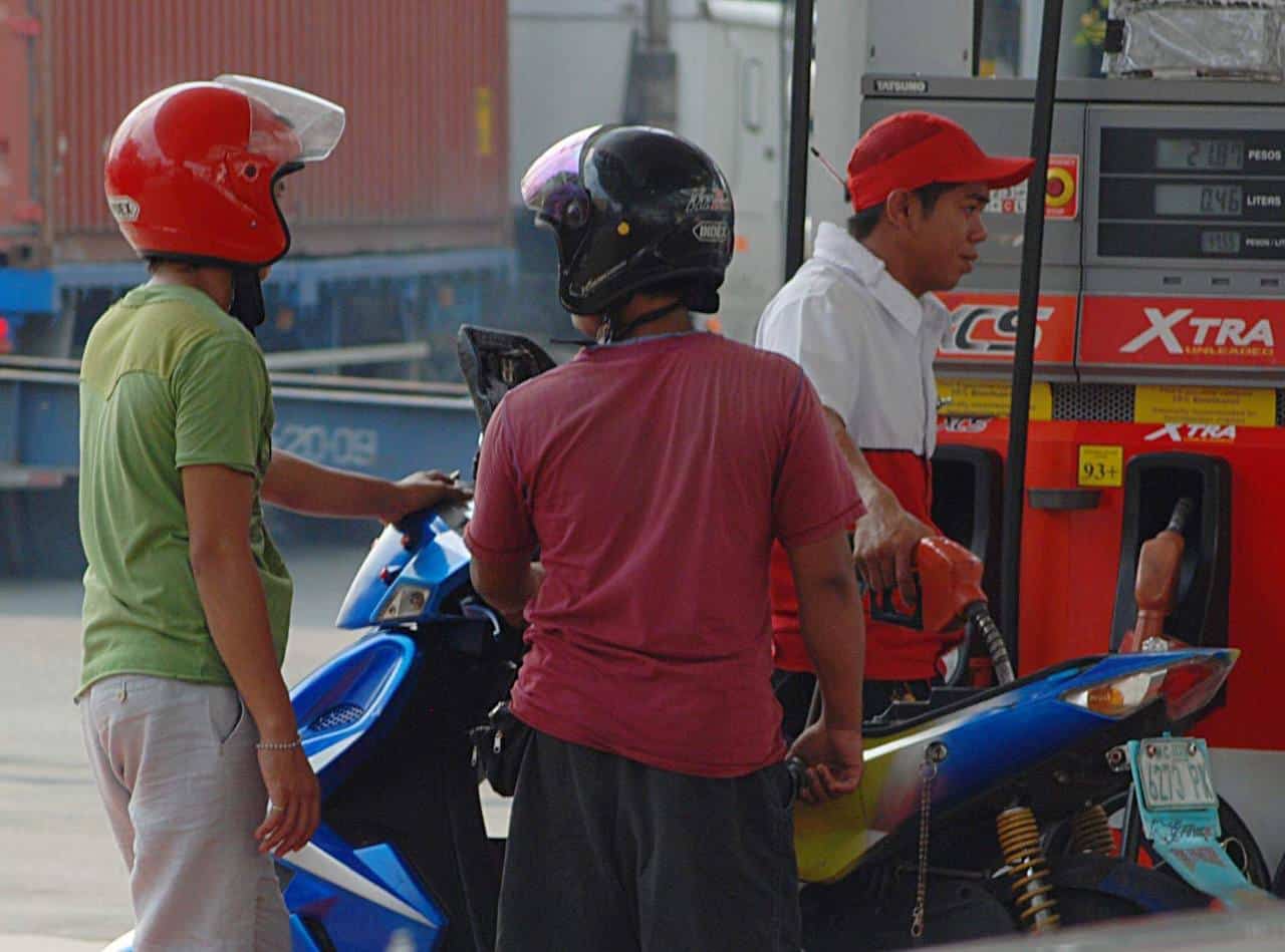 Motorcycle riders waiting to fill up their gas tanks