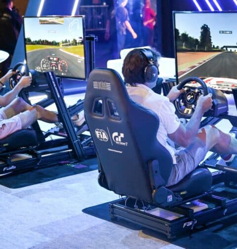 Visitors try out a race simulator before the start of the competition during the Olympics Esports Week in Singapore on June 22, 2023. (Photo by Roslan Rahman / AFP)