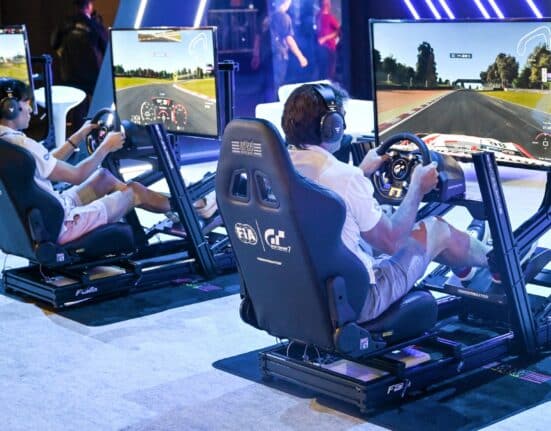 Visitors try out a race simulator before the start of the competition during the Olympics Esports Week in Singapore on June 22, 2023. (Photo by Roslan Rahman / AFP)