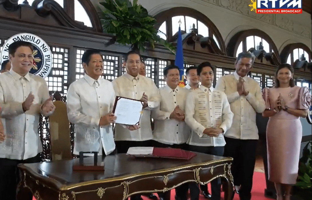 President Ferdinand Marcos Jr. presents a signed copy of the Maharlika Investment Fund Act (Republic Act 11954) at a ceremony in Malacanang on Tuesday, July 18, 2023. (Screengrab from RTVM video)