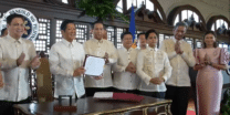 President Ferdinand Marcos Jr. presents a signed copy of the Maharlika Investment Fund Act (Republic Act 11954) at a ceremony in Malacanang on Tuesday, July 18, 2023. (Screengrab from RTVM video)