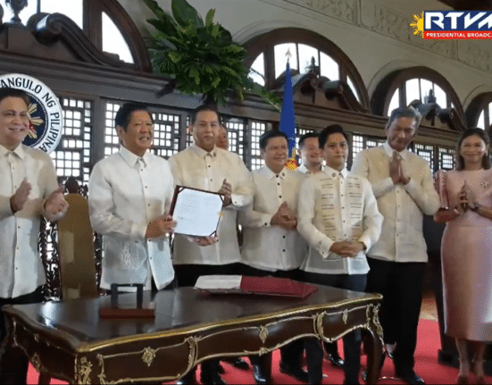 President Ferdinand Marcos Jr. presents a signed copy of the Maharlika Investment Fund Act (Republic Act 11954) at a ceremony in Malacanang on Tuesday, July 18, 2023. (Screengrab from RTVM video)