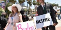 Cosplayers hold Barbenheimer signs outside the convention center during San Diego Comic-Con International in San Diego, California, on July 21, 2023. (Photo by Chris Delmas / AFP)