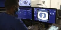 Medical Radiology Manipulator Ludovic Foy look at his screen as he takes a lung scan on a smoking woman for the Acapulco experimentation in Ajaccio on December 16, 2021 on the French Mediterranean island of Corsica. (Photo by Pascal POCHARD-CASABIANCA / AFP)