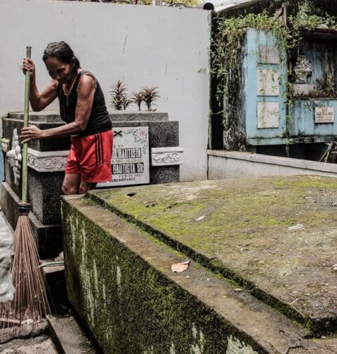 A woman cleans graves at the Manila North Cemetery on Wednesday, Oct. 25, 2023 (Ryan Baldemor/republicasia)