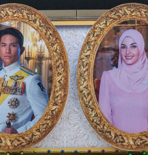 The portraits of groom Prince Abdul Mateen (L) and his bride Yanh Mulia Anisha Rosnah (R) are seen on a billboard ahead of their wedding procession in Bandar Seri Begawan on January 13, 2024. (Photo by Mohd RASFAN / AFP)