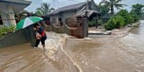 A man wades through floodwaters brought about by heavy rains at a residential neighbourhood in Propseridad town, Agusan del Sur province on southern Mindanao island on February 1, 2024. - Floods and landslides triggered by torrential rain have killed six people in the Philippines, with one other person missing, rescuers said February 1. (Photo by Erwin MASCARINAS / AFP)