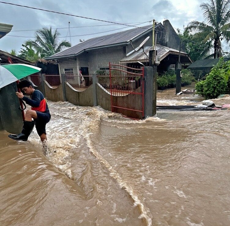 A man wades through floodwaters brought about by heavy rains at a residential neighbourhood in Propseridad town, Agusan del Sur province on southern Mindanao island on February 1, 2024. - Floods and landslides triggered by torrential rain have killed six people in the Philippines, with one other person missing, rescuers said February 1. (Photo by Erwin MASCARINAS / AFP)